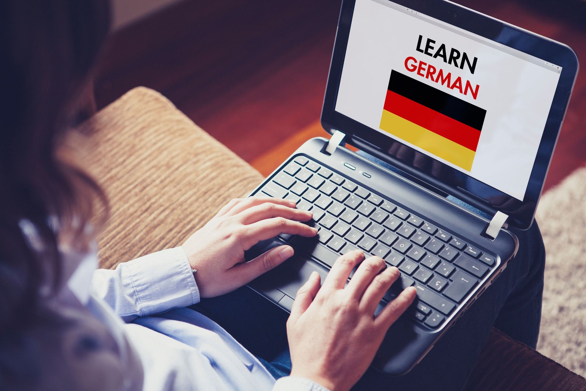 Female learning german at home with a laptop.